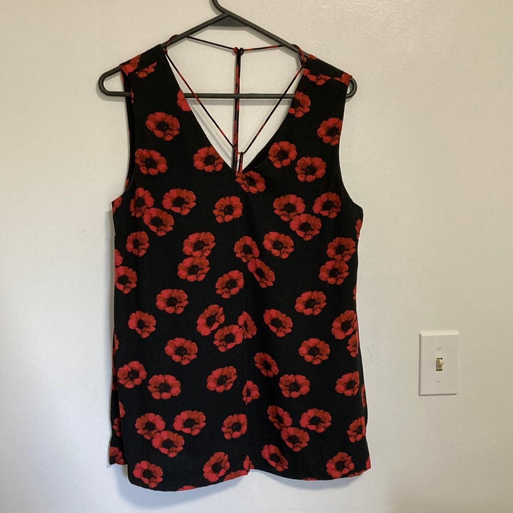 Noir black sleeveless top with poppy print. Unique neck detail.